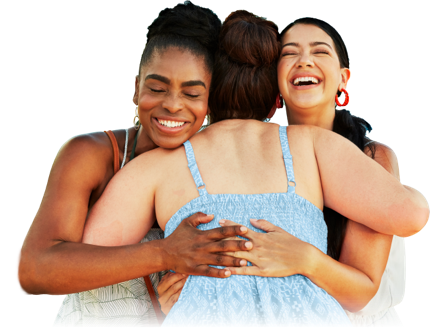 Three women embrace while smiling